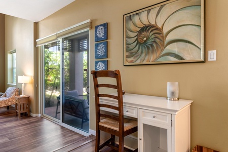 A quiet workspace awaits you, bathed in natural light from the sliding glass door leading to your private outdoor seating area. Coastal-inspired decor and warm wood floors create a relaxing retreat where you can unwind.