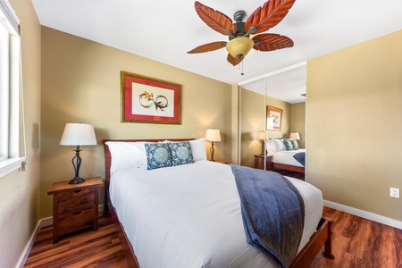 Sink into crisp white linens and let the tropical ceiling fan keep you cool. The mirrored closet doubles your space, while warm wood accents create a relaxing island retreat just for you.