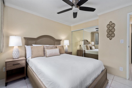 - Rest easy in this cozy queen bedroom with neutral tones and mirrored closet - Ceiling fan keeps the air fresh while soft lighting adds a calming glow - Stylish wood furniture and plush bedding offer a perfect sleep sanctuary