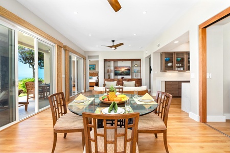 - Dining area with glass top table set for four & natural wood chairs creating an inviting feel - Large sliding doors offering scenic views and abundant natural sunlight - Open flow connects to the living room for easy entertaining and relaxed gatherings