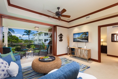 - Cozy living room with TV console, ceiling fan, and vibrant area rug   - Stylish glass doors connect the space to an outdoor seating area   - Ideal for movie nights or enjoying the island breeze from indoors
