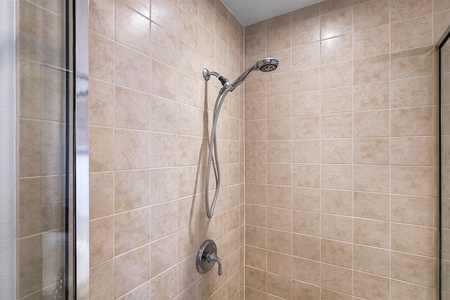 - Close up of tiled shower with modern fixtures and adjustable showerhead   - Neutral tones create a calm and spa like atmosphere for your routine   - Spacious design ensures comfort and ease during your daily refresh