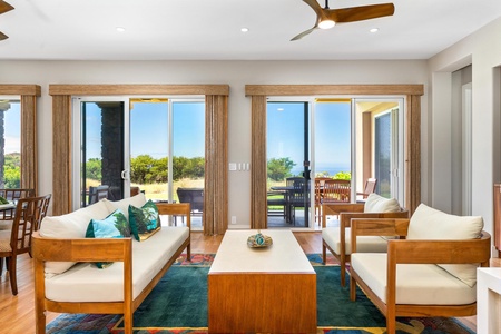 - Bright sitting space with sleek wood furniture & teal accent pillows for a fresh look - Glass doors open to a covered patio with ocean views & breezy open air relaxation - Minimalist decor & clean lines create a serene inviting spot to unwind in style