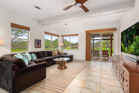 Relax in your spacious living room with plush sectional seating, tropical views through large windows, and entertainment center for perfect vacation evenings.