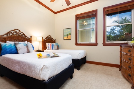 - Cozy guest bedroom with two twin beds and crisp white bedding   - Colorful pillows and wall art bring a playful touch to the space   - Large windows let in plenty of natural light for a cheerful atmosphere