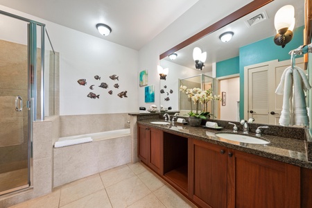 Ensuite primary bathroom with double vanity, walk-in shoer, and soaking tub