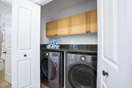 Keep your wardrobe fresh with this convenient in-unit laundry nook, complete with full-size washer and dryer tucked neatly behind elegant cabinetry.