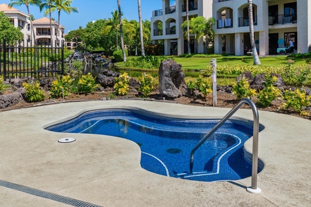 Spacious resort complex featuring tropical landscaping with palm trees, volcanic rock gardens, and well-maintained grounds surrounding residential buildings.