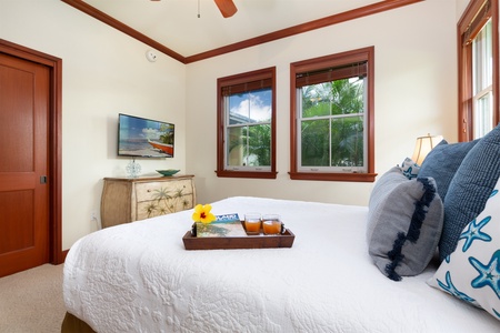 - Bright bedroom with queen bed and tray set for a relaxing morning in bed   - Dual windows frame leafy greenery and let in refreshing breezes   - Flat screen TV and dresser offer convenience and entertainment