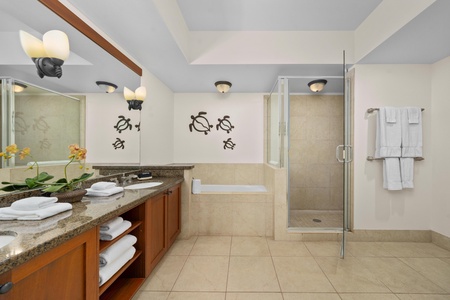 Relax in your spa-like bathroom with soaking tub, walk-in shower, and tropical turtle artwork creating a peaceful island vibe.