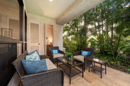 Step onto your covered patio and sink into comfortable wicker seating surrounded by lush tropical palms—your perfect outdoor retreat awaits.