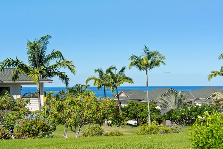 Serene ocean backdrop with tropical greenery and rooftops.
