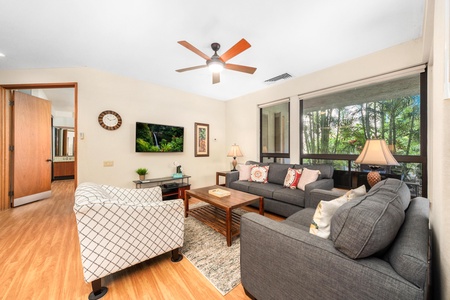 Unwind in your spacious living room with plush sectional seating, tropical garden views, and modern comforts for perfect relaxation.