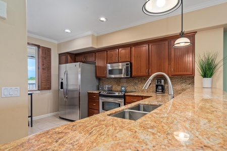 Full kitchen with breakfast bar, granite counters, and stainless steel appliances
