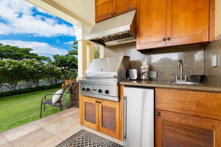 - Outdoor kitchen with stainless steel grill, mini fridge, and sink for easy meal prep   - Warm wood cabinetry adds style to the functional cooking space   - Covered design offers shade while enjoying fresh island breezes
