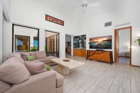 - Relax in the spacious living room with large screen TV and tropical wood furnishings - Airy and open, with light streaming in from every direction through tall glass doors - Ideal for movie nights, conversations, or just lounging in paradise