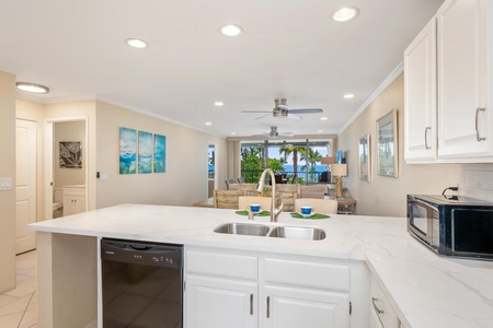 - Stay connected with guests while prepping meals in this open concept kitchen - Island sink and breakfast bar overlook the living room and scenic lanai beyond - Light tile floors and recessed lighting keep things airy and bright