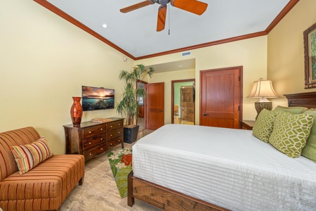 Relax in your comfortable bedroom with high ceilings, a ceiling fan for warm evenings, and cozy seating. The crisp linens and tropical touches create a peaceful retreat after your day of adventure.
