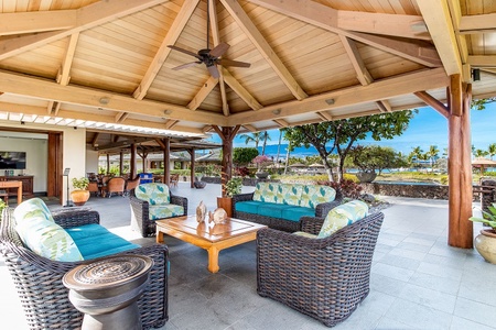 Open air lounge with cushioned seating under a vaulted wood ceiling.
