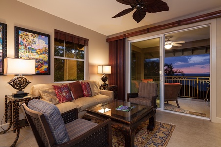 - Cozy living room glows in the warmth of sunset with views of the ocean from your sofa - Plush seating and tropical ceiling fan invite you to unwind indoors or out - Sliding glass doors open to the lanai where golden hour never disappoints