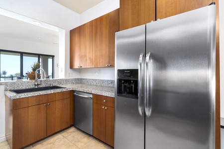 - Kitchen corner with stainless fridge and dishwasher for convenience   - Granite counters and warm cabinetry create a stylish modern look   - Functional layout makes meal prep and cleanup both easy and efficient