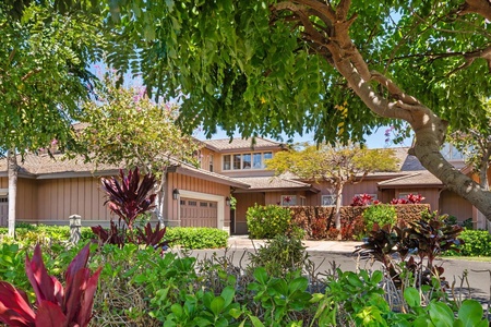 Townhome exterior framed by colorful landscaping and greenery.