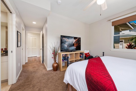 - Bold red bedding adds a splash of color in this calm and welcoming bedroom - Stylish cube shelf holds a smart TV and accessories for your convenience - Hallway access makes this room ideal for guests or family members alike