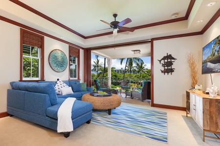 - Bright living space with blue sectional, woven coffee table, and tropical décor accents   - Large sliding doors open to a covered lanai with beautiful palm views   - Perfect blend of indoor comfort and outdoor relaxation