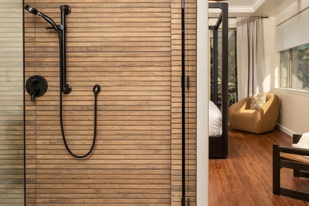 Unwind in your stylish ensuite with sleek black fixtures and warm wood accents, then sink into the cozy reading chair.