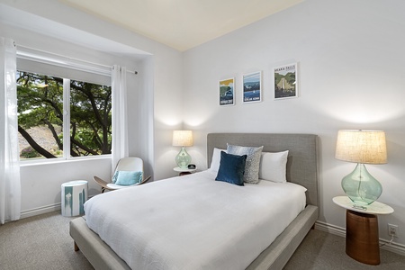 - Bright bedroom with soft neutral tones and a plush queen bed for comfort   - Large window frames beautiful green views and fills the room with daylight   - Thoughtful decor and cozy seating create a peaceful restful atmosphere