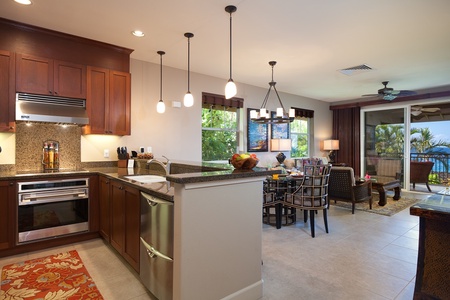 - Modern kitchen flows effortlessly into the dining and living space for a seamless layout - Pendant lighting and granite counters add style and function - Great for entertaining or casual meals with views of the beautiful surroundings