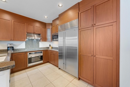 Your gourmet kitchen features warm wood cabinetry, granite counters, and premium stainless appliances perfect for creating memorable meals.