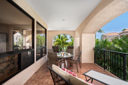 Savor your morning coffee on this spacious covered balcony, where tropical breezes and lush palm views create your perfect outdoor retreat.