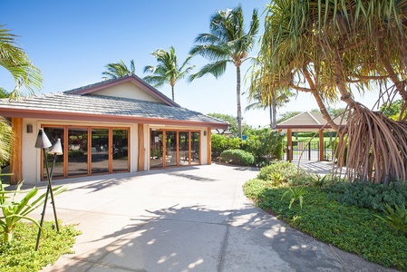 Clubhouse building with outdoor seating and landscaped pathways.