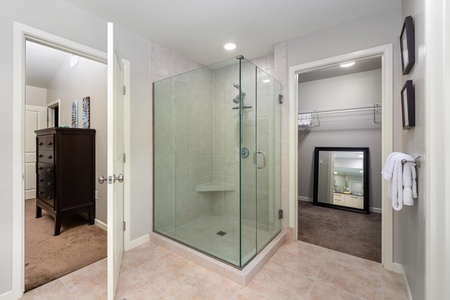- Refresh in the large walk in glass shower with built in bench and rainfall head - Direct access to a spacious closet with full length mirror and extra storage - Modern tile floors and neutral walls add a serene spa like touch throughout