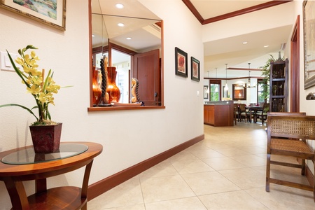 - Bright hallway with tile flooring and decorative wall art for a warm welcome   - Features a console table with mirror and accent lighting   - Opens into the main living, dining, and kitchen areas for a seamless flow