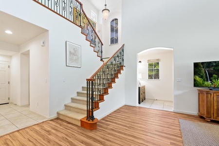 - Staircase with wrought iron rails anchors this airy and spacious entry.