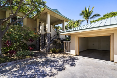 - Exterior view of property with covered entry and tropical landscaping   - Includes private garage and driveway for convenient guest parking   - Elevated design offers scenic surroundings and welcoming curb appeal