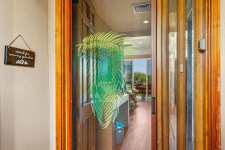 Welcoming entry view with a tropical touch reflected on glass.