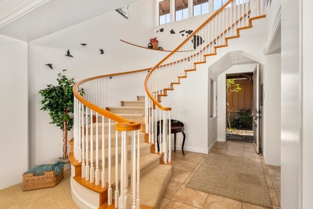 - Eye catching curved staircase leads to the upper level with style - Vaulted ceiling and wall art add depth and personality to the entry - Beautiful welcome every time you enter this bright and airy home