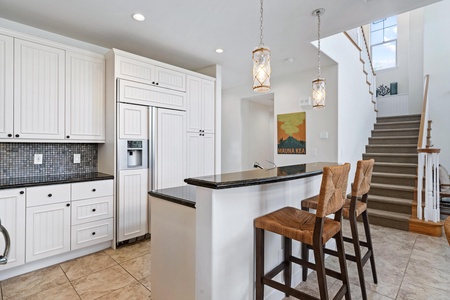Full kitchen with breakfast bar, granite counters, and modern appliances