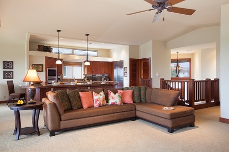 - Open concept living area with plush sectional and colorful pillows   - Warm wood cabinetry and pendant lighting accent the modern kitchen   - Spacious layout connects cooking, dining, and lounging seamlessly