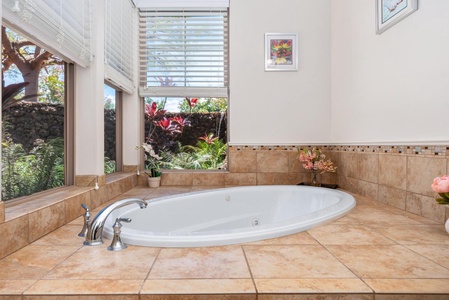 - Slip into this inviting tiled soaking tub framed by blooming garden views - Large windows let in soft natural light while ensuring perfect privacy - Touches of floral décor and framed art elevate the serene atmosphere
