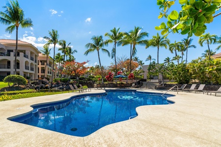 Dive into paradise with this stunning resort-style pool surrounded by swaying palms and tropical blooms in your island oasis.