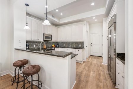 You'll love cooking in this bright, fully-equipped kitchen featuring granite counters, stainless appliances, and a breakfast bar for casual dining.