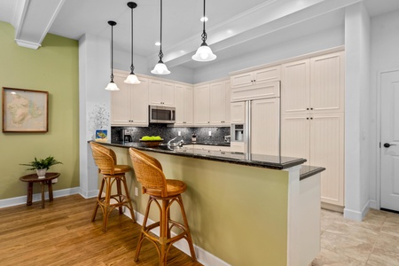 Full kitchen with breakfast bar, granite counters, and modern appliances