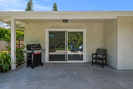 Fire up the grill on your private covered patio, perfect for outdoor dining with views of lush gardens through sliding glass doors.