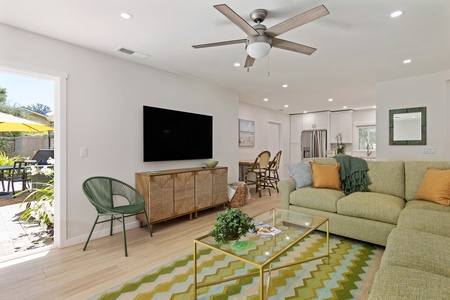 Your bright living space features a plush sectional, large TV, and seamless indoor-outdoor flow through glass doors to your private patio.