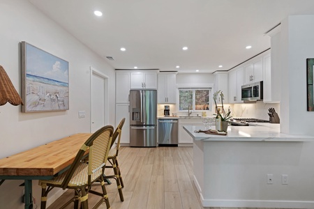 Your gourmet kitchen awaits with pristine white cabinets, stainless steel appliances, and a spacious island for cooking adventures.