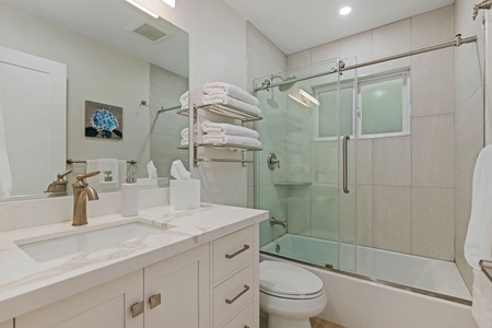 Step into your spa-like retreat with elegant quartz counters, plush towels, and a luxurious glass-enclosed shower for pure relaxation.